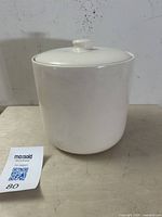 Front view of white glazed Bauer pottery cookie jar with lid on table.