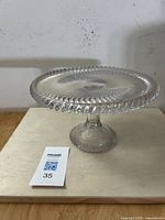 Side angle showing the pedestal and swirl pattern on the plate and scalloped edge