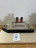Front view of the folk art oceanliner model showing the bow, railings, smokestacks and hull detail.