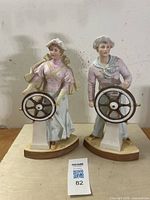 Front view of both Gebrüder Heubach bisque porcelain sailor figurines, showing the ship's wheels and detailed clothing