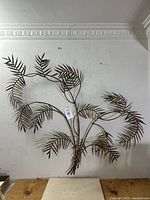 Front view of large Mid-Century Italian gilt metal leaf wall sculpture on white wall.