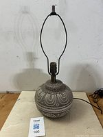 Full view of spherical ceramic table lamp with metal socket and harp