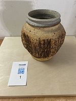 Front view of mid-century Brutalist pottery vase showing textured body, incised linear markings and smooth glazed rim