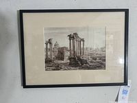 Framed monochromatic sepia watercolor painting of the Roman Forum, showing ruins of columns and ancient buildings, mounted on the wall.