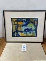 Full view of framed abstract watercolor painting with visible colors and frame.