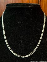 Front view of the sterling silver fancy link chain necklace displayed on black velvet bust.