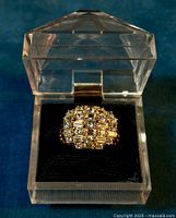 Front view of the ring in a transparent display box showing the detailed CZ stone setting and gold wash finish.