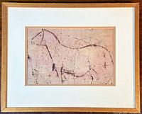 Framed print showing the 'Spanish nanny-goat' Paleolithic rock painting image, with natural cracks and aged effect on the print surface.