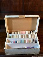 Open box showing three large compartments filled with sports cards arranged vertically.