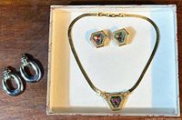 Vintage Oscar De La Renta pentagonal necklace with matching earrings displayed in original box lid, along with additional silver-tone oval hoop earrings.