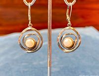 Front view on stand showing swirl design and pearl center