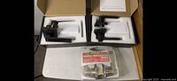 Three door levers including two black used ones and one silver new one in packaging.