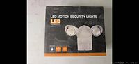 Front of the box showing the LED motion security light with three LED heads and LED technology, 20W power.