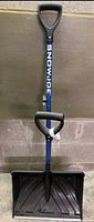 Full view of Snow Joe snow shovel showing blue metal handle with logo, two black D-shaped grips, and wide black plastic scoop.