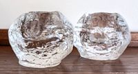 Pair of textured clear glass votive holders side by side showing rounded, irregular snowball style surfaces.