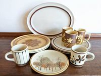 Lot overview showing 7 stoneware items including plates and mugs with earth tone designs