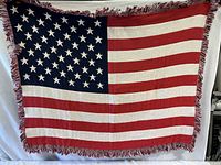 Full view of the blanket showing the stars and stripes pattern with fringed edges.