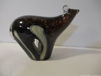Front and side view of a brown and white mouse-shaped art glass sculpture showing the shape, color, and details like clear glass ears and nose.