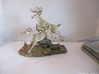Photo of the full deer figurine sculpture with a white background showing details of the deer and naturalistic base