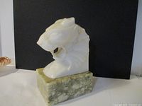 Front angle of the white marble tiger head mounted on a green marble base bookend, showcasing the detailed carving and size.