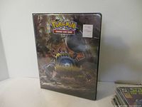 Front cover of the Pokemon trading card binder with character artwork and price sticker.