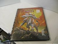 Black binder for Pokemon trading cards showing Pokemon character on the cover with a sticker price