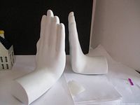 Front and side views of white hand-shaped stone bookends