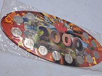 Full view of 12 Canadian quarters attached to colorful backing card with '2000' and Canada map design.