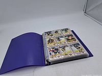 Binder open to page displaying nine Boston Bruins cards.