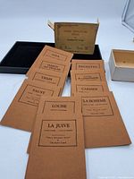 Full set of 10 brown paperback Opera Miniature Series publications arranged in front of the original black box with paper label.