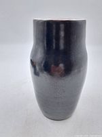Full front view of the glazed ceramic vase showing its dark gradient and glossy finish.