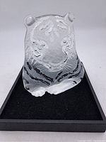 Front view of the lead crystal tiger figurine showing etched facial and stripe details, displayed on black felt base.