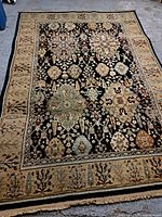 Full view of the carpet showing the complete pattern and overall condition on a concrete floor.