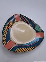 Top view of the vintage triangular Rosenthal ceramic dish showing geometric pattern with blue, pink, yellow, black and green colors and cream interior.