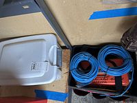 Image showing Husky tool caddy with large coiled blue Cat 5 cables and an orange box inside the caddy.