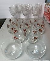 Front view showing 6 rose water glasses with etched floral pattern, 8 fox motif tumblers behind and 2 clear glass bowls located in front.