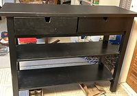 Front-facing view of the black kitchen island showing two drawers and two open shelves.