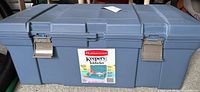 Front view of the Rubbermaid Keepers Totelocker plastic storage box with two metal latches and product label on the front center.