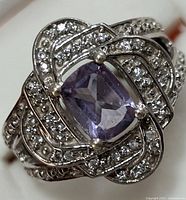 Close-up view of the front of the ring showing the cushion-cut central amethyst and surrounding cubic zirconia set in sterling silver.