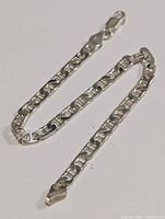 Full view of silver link chain bracelet with lobster claw clasp on a white background.