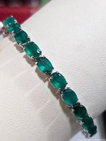 Close-up angle of the silver bracelet with oval green onyx stones highlighting stone color and setting.