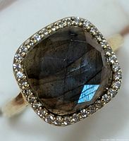 Close-up of the square cushion-cut faceted labradorite on silver ring with clear stone halo, highlighting stone and setting details.