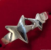 Close-up image of silver ring with two star-shaped embellishments on the band.