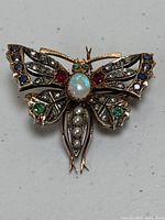 Front view of entire butterfly brooch showing gemstone placement and overall design