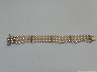 Full view of the triple strand pearl and diamond bracelet laid flat