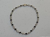 Full view of the 18K white gold sapphire and diamond bracelet laid flat