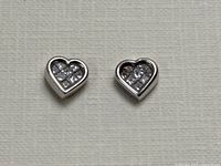 Front view of both heart-shaped white gold earrings showing grid of diamonds