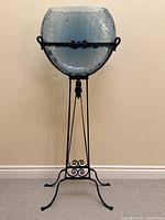 Full view of fishbowl mounted on stand against wall