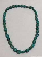 Full view of necklace laid flat on white background showing all beads