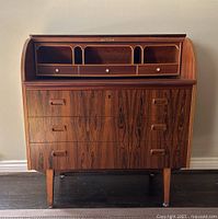 Front view of desk with roll-top closed and three lower drawers